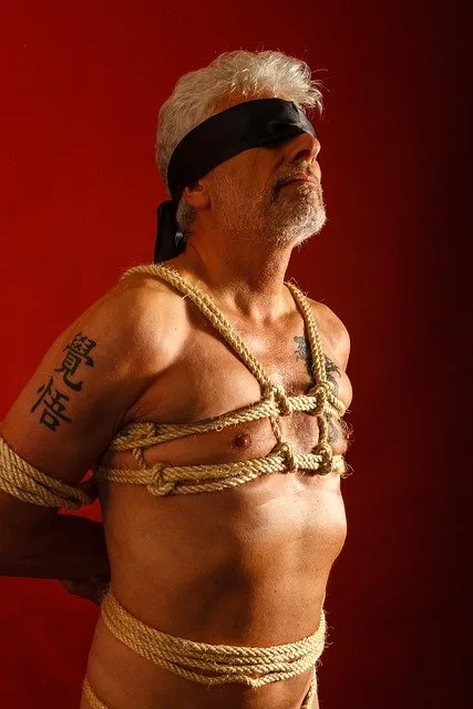 Gefesselte Handgelenke hinter dem Rücken bei einer Bondage-Session